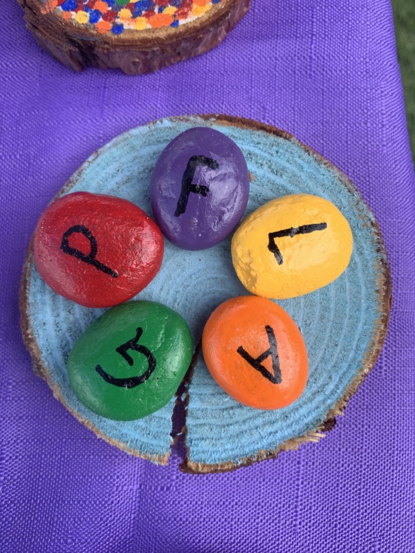 Circle of painted rocks that spell the word PFLAG